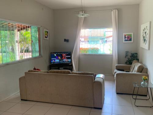 a living room with two couches and a tv at CASA LAGOA DO BANANA/CUMBUCO in Caucaia