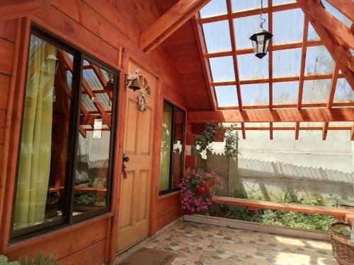 eine Veranda eines Hauses mit Glastür in der Unterkunft Cabañas El Diuco en Coñaripe 4 in Coñaripe