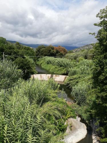 a bridge over a river in a field at Monolocale con giardino e parcheggio privato CITRA zero zero ottanta trentuno LT 0281 in Imperia