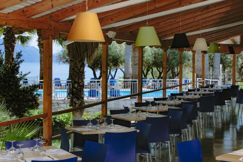 una sala da pranzo con tavoli, sedie blu e luci di HOTEL SISSY a Kamena Vourla