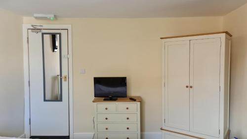 a bedroom with a dresser and a tv on a cabinet at Grace Apartments - Living Rock in Ashford