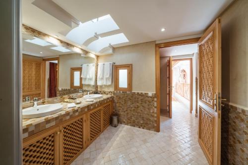 a bathroom with two sinks and a large mirror at La Maison Arabe Hotel, Spa & Cooking Workshops in Marrakech