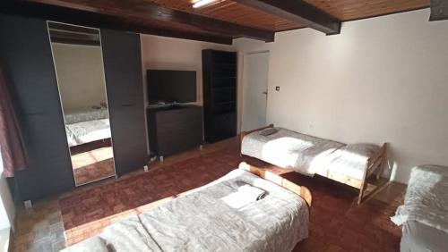 a room with two beds and a flat screen tv at Hostel Komfort Borek in Krakow