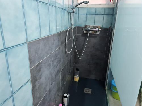 una ducha con una manguera pegada a una pared de azulejos en Enrique Número 68, en Elche