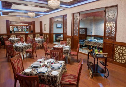 a dining room with tables and chairs in a restaurant at Ramada Plaza by Wyndham Gence in Ganja