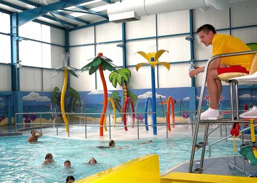 un homme assis sur une chaise dans une piscine dans l'établissement Golden Palm Chapel St Leonards 8 Berth 3 Bedroom Caravan, à Skegness