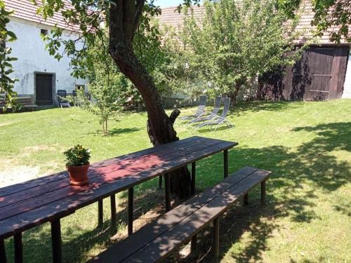 a wooden picnic table sitting next to a tree at Chalupa u Brčáků in Ktiš