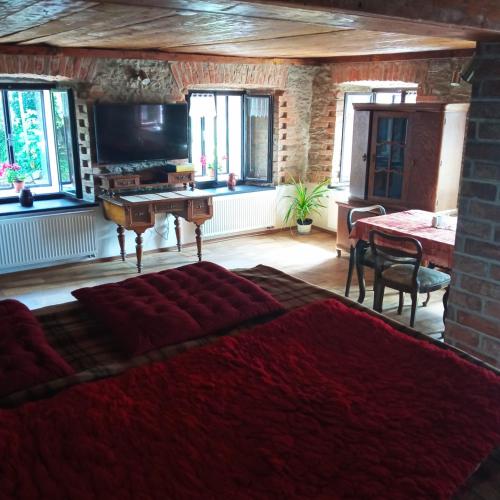 a bedroom with a bed and a table with a piano at Chalupa u Brčáků in Ktiš