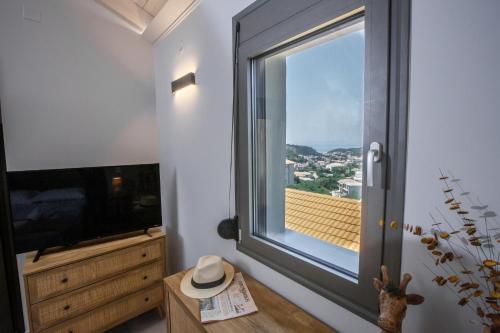 a room with a large window and a television at Théa boutique villas sivota III in Sivota