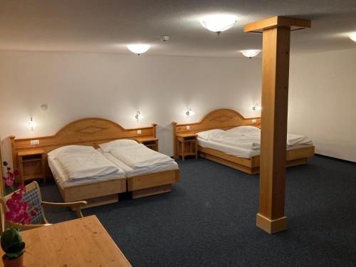 a room with two beds and two tables at Chemihüttli Apartments Axalp in Axalp