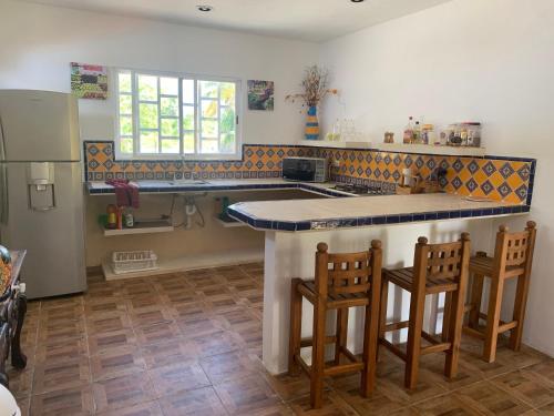 een keuken met een aanrecht en een aantal stoelen. bij Arenas Del Mar Condos in Chelem