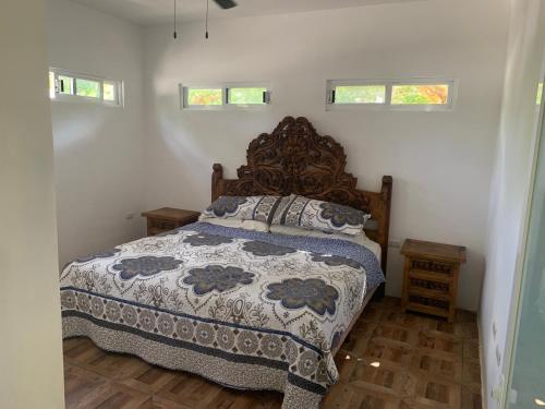 een slaapkamer met een bed met een houten hoofdeinde en ramen bij Arenas Del Mar Condos in Chelem