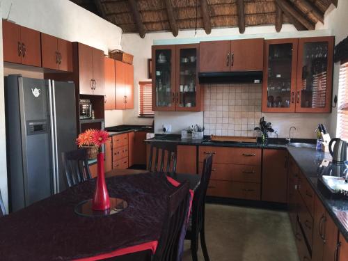 a kitchen with a table and a refrigerator at Waterberg INN in Modimolle
