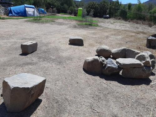 a bunch of rocks in a field with a tent at S'Imbragu Farm B&B in Tortolì