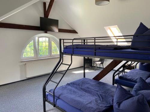 a room with three bunk beds and a window at Villa Schomberg in Spremberg