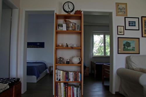 a room with a book shelf with books and a clock at Holiday Home Anja in Supetar