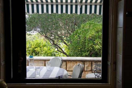 a table and chairs on a balcony with a tree at Holiday Home Anja in Supetar