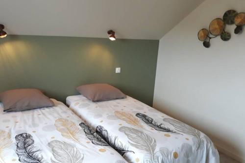 two twin beds in a room with green walls at La Cascatelle - Gîte entièrement climatisé in Savigny-en-Revermont