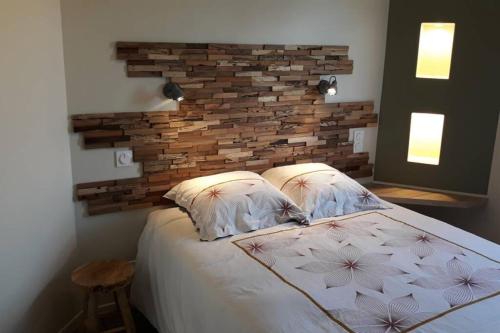 a bedroom with a bed with a brick wall at La Cascatelle - Gîte entièrement climatisé in Savigny-en-Revermont