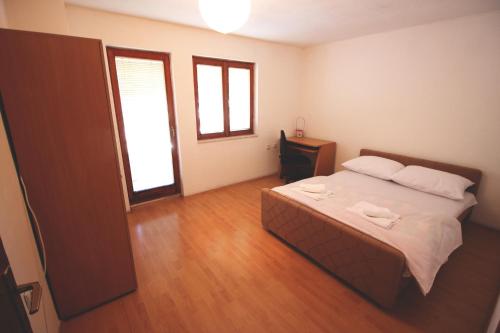 - une chambre avec un lit et 2 fenêtres dans l'établissement Apartman Komfor, à Banja Luka