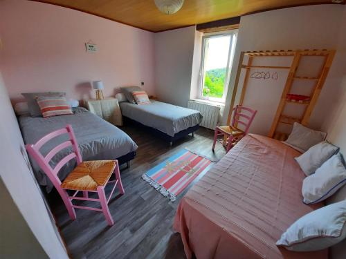 1 dormitorio con 2 camas y ventana en Le Logis des 3 Coeurs chambre Aeiou en Saint-Cernin-de-lʼHerm