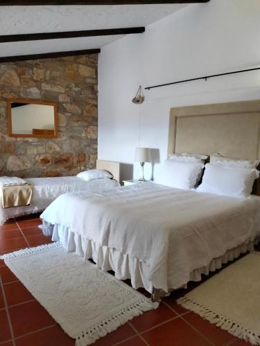a bedroom with two beds and a stone wall at Casa de Chanca in Penela