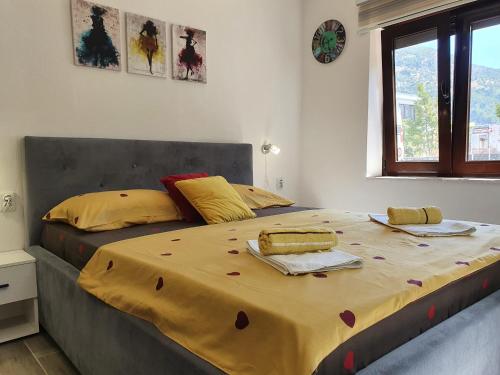 a bedroom with a large bed with a yellow blanket on it at Studio Milenic in Trebinje