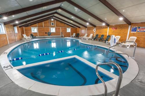 une grande piscine au milieu d'un bâtiment dans l'établissement All Seasons Inn & Suites, à Bourne