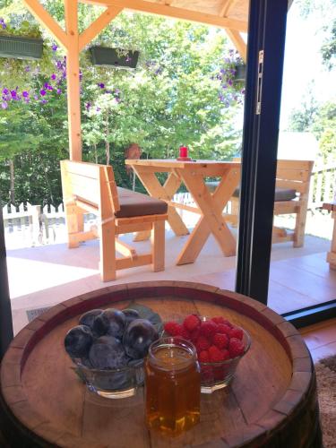 a table with bowls of fruit and a drink on a patio at Koliba Pčelica 2 in Bijelo Polje