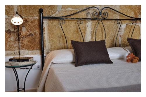 a bed with a metal headboard and a side table at Morfeo Charming Rooms & Relax in Avola