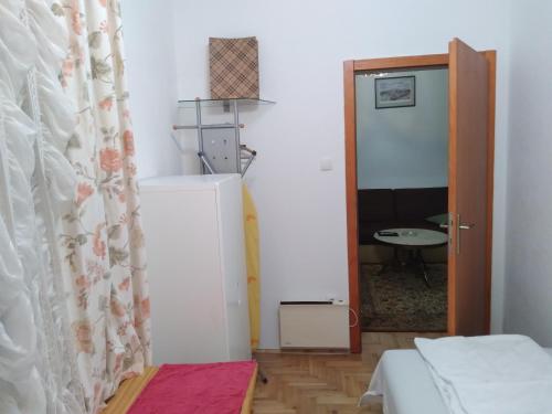 a small room with a refrigerator and a door at Apartman Centar in Banja Luka