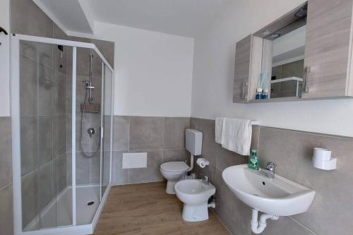 La salle de bains est pourvue d'un lavabo, de toilettes et d'une douche. dans l'établissement Casa Adelina - Appartamento Pallanza centro, à Verbania