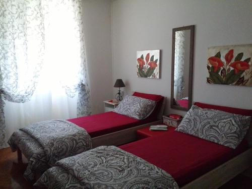 a bedroom with two beds and a mirror at Casa di Alice in Gorizia