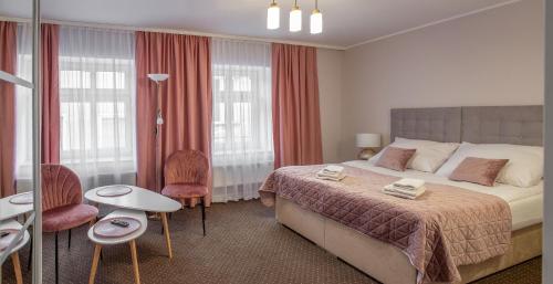 a bedroom with a bed and a table and chairs at Kamienica Pod Neptunem in Puck