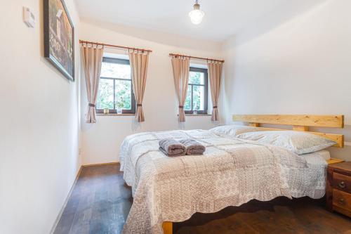 a bedroom with a bed with two slippers on it at Buškovský mlýn 1580 in Dolní Bousov