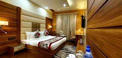 a hotel room with a bed and a desk at Hotel Makhan Residency in Amritsar