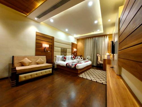 a bedroom with a bed and a couch in it at Hotel Makhan Residency in Amritsar