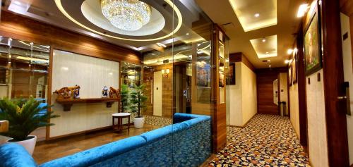 a lobby with a blue couch in a building at Hotel Makhan Residency in Amritsar