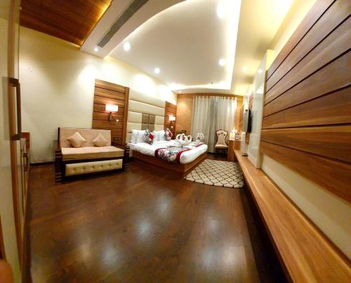 a bedroom with a bed and a couch in a room at Hotel Makhan Residency in Amritsar