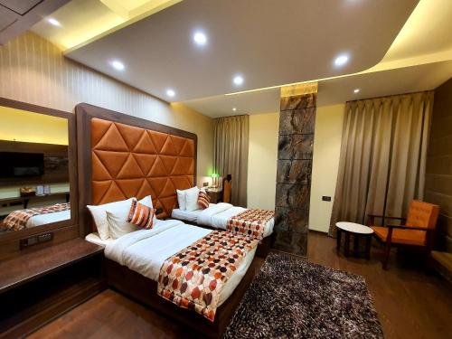 a hotel room with a large bed and a desk at Hotel Makhan Residency in Amritsar
