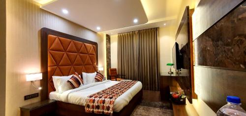 a bedroom with a large bed in a hotel room at Hotel Makhan Residency in Amritsar