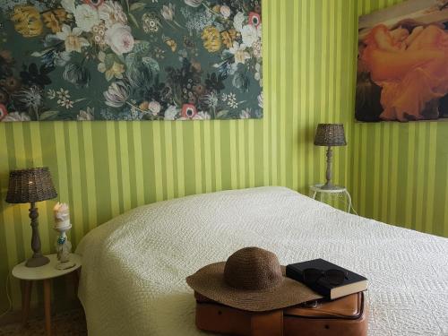 a bedroom with a bed with a hat on it at Dimora in San Quirico d'Orcia in San Quirico dʼOrcia
