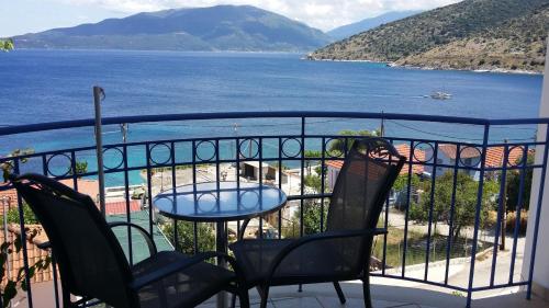 a balcony with a table and chairs and a view of the water at Olive Bay Hotel in Ayia Evfimia