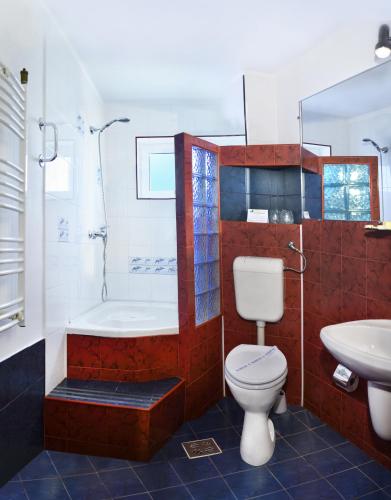 a bathroom with a toilet and a tub and a sink at Hotel Albatros in Mamaia