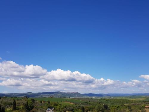 a blue sky with clouds over a green field at Dimora in San Quirico d'Orcia in San Quirico dʼOrcia