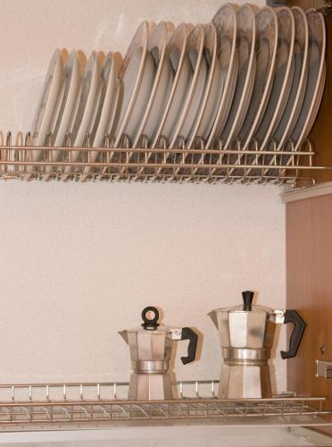 a shelf with plates and utensils in a kitchen at Appartamento incantevole con parcheggio gratuito in Tirano