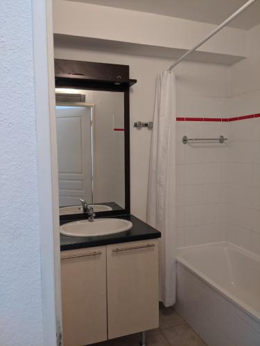 une salle de bain avec un lavabo, une baignoire et un miroir dans l'établissement Maisonnette dans domaine avec piscine à Nyons, pays des olives, à Nyons