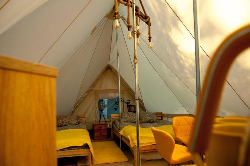 Una habitación con una tienda de campaña con camas. en Glamping z alpakami en Jankowice