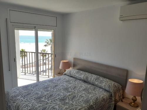 Schlafzimmer mit einem Bett und Strandblick in der Unterkunft Apartamentos Dins Mar Apto. 5 in Torredembarra
