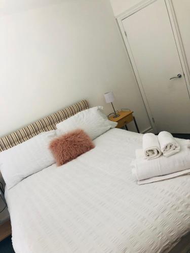 um quarto com uma cama branca e toalhas em The Borough apartment em Kent